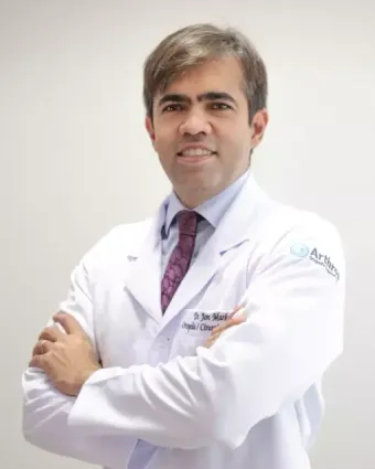 Retrato do Dr. Jon Marks de jaleco, com os braços cruzados